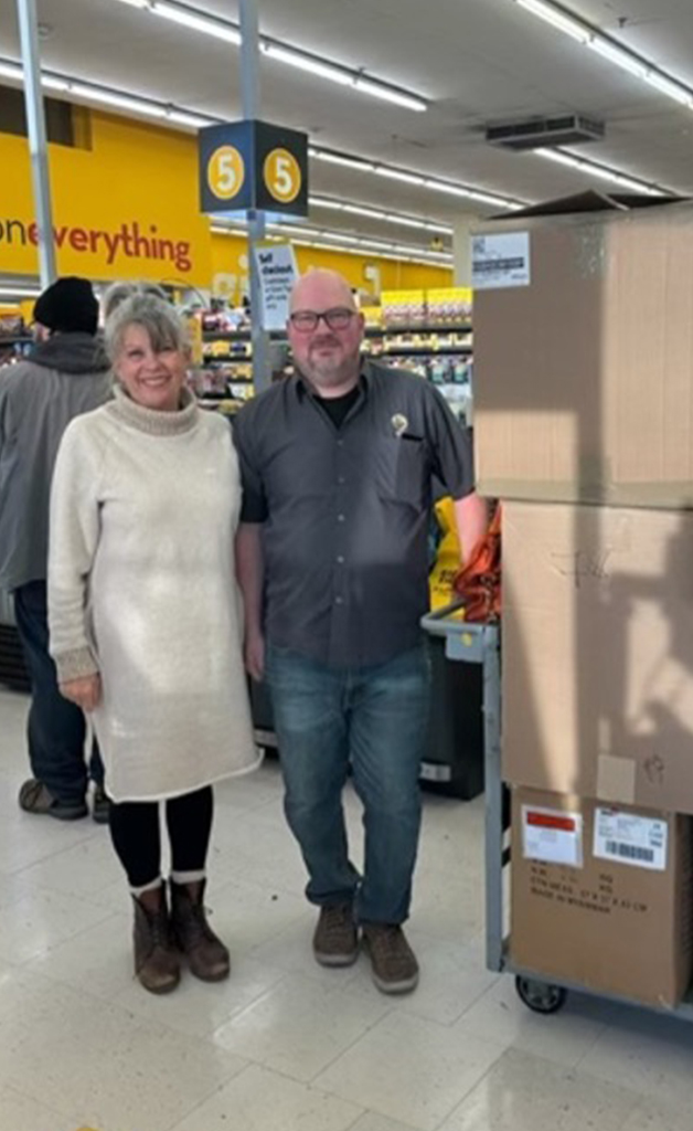 Denise Dubé, membre du Club Richelieu, et Colin Taylor, gérant adjoint du Giant Tiger, remplissent des boîtes de manteaux d'hiver pour enfants destinés à La Friperie.
